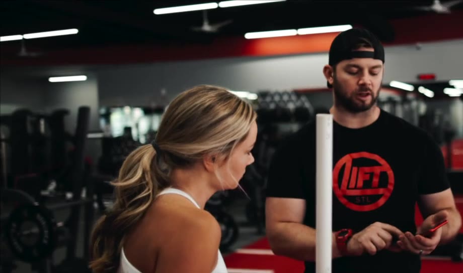 A Lift STL coach talking through a plan with a client on the gym floor